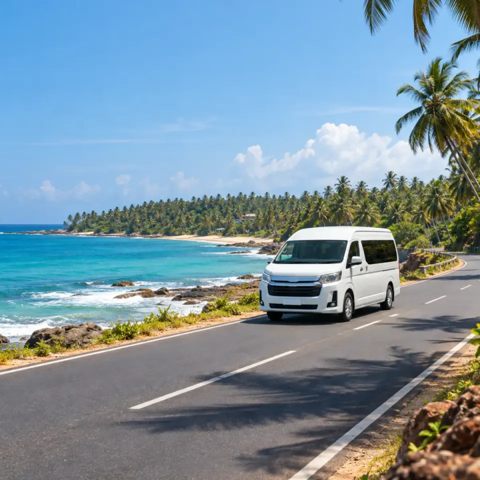 White private van on a coastal road beside the sea in Sri Lanka